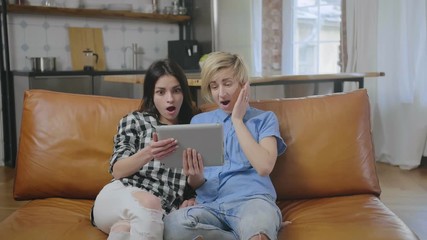 Lesbians using tablet on couch