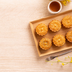 Mid-Autumn Festival holiday concept design of moon cake, mooncakes, tea set on bright wooden table with copy space, top view, flat lay, overhead shot