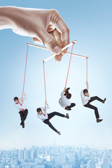 Conceptual image of businessman puppet on gray background. Caucasian male model trying not to...