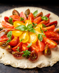 Summer cake with cherry tomatoes, brie cheese and basil. Baking dough with vegetables, greens.
