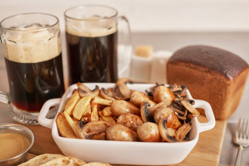 selyansky potatoes with sausages, bread and dark beer on the oktoberfest table