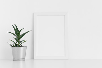 White frame mockup with a aloe vera in a pot on a white table. Portrait orientation.