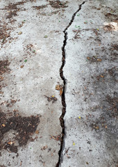 Dirty concrete pavement with a crack. A crack in the concrete.