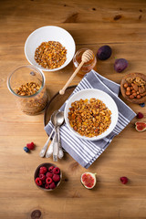 Granola  in bowls and jar on wooden table