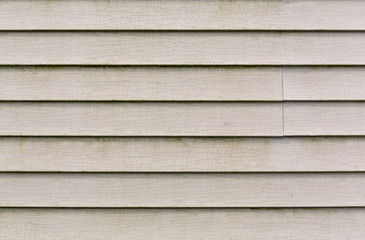 Very dirty beige vinyl siding