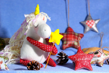 Soft toy of unicorn girl with christmas toys stars. Children's interior fabric toy for kids room decor. New year holidays