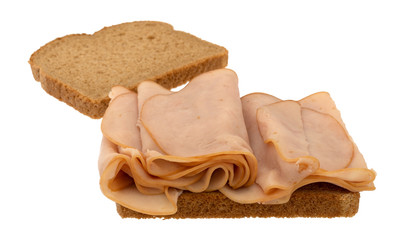 Thin sliced smoked turkey sandwich on a white background