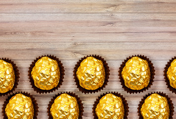 golden premium chocolate sweets isolated on wood table, happy valentine's day concept 