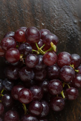 The bunch of red grape on wooden floor