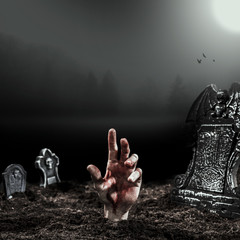 Alive hand protruding from grave in moonlight