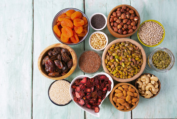 nuts, seeds and dried fruis on wooden surface