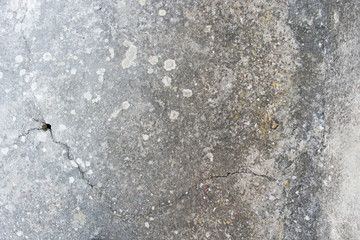 close up on real old concrete wall, cracked and dirty with small hole
