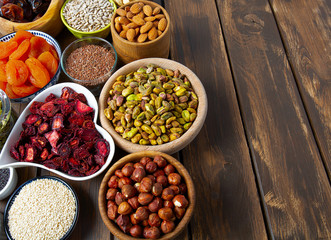 nuts, seeds and dried fruis on wooden surface