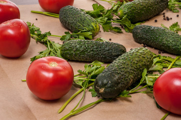Organic vegetables tomatoes cucumbers parsley over craft paper. Zero waste, plastic free concept. Healthy clean eating diet and detox. Top view, flat lay. Veggie ingredients for cooking.