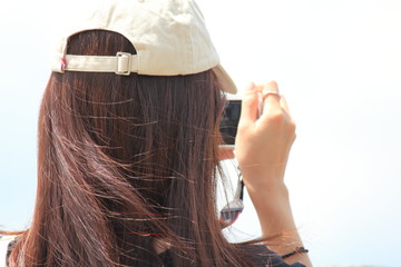 A woman is taking a photo in front of beautiful lake.
