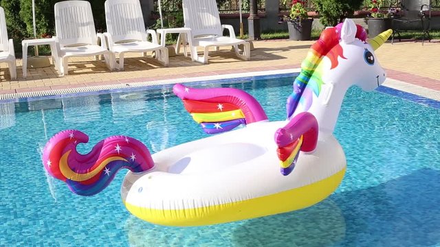 Unicorn pool float in swimming pool blue water background. Unicorn inflatable float for kids and adult.