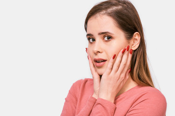 Fototapeta premium Close-up studio shot of amazed beautiful young woman looking at one side with surprised expression and wide open mouth. Excited Caucasian female, looking shocked posing instudio. People and emotions