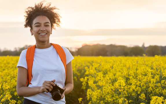 Mixed Race African American Girl Teenager With Camera In Yellow Flowers