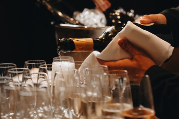 Pouring champagne into wine glasses. Champagne flutes on a wedding or new year eve party © loki_ast