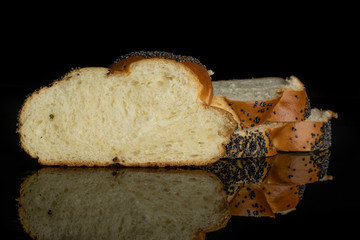 Group of three slices of fresh twisted poppy seed bun isolated on black glass