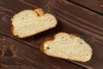 Group of two slices of twisted poppy seed bun flatlay on brown wood