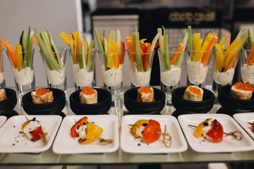 Beautifully decorated catering banquet table with different food snacks and appetizers with sandwich, caviar, fresh fruits on corporate christmas birthday party event or wedding celebration