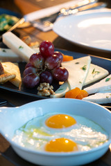 Breakfast with fried egg and cheese plate on wooden table