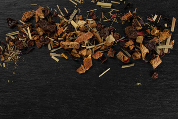 Lot of pieces of lingonberry strawberry fruit tea copyspace below flatlay on grey stone