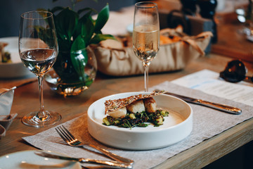 tableware Glasses, flower fork, knife served for dinner in restaurant with cozy interior