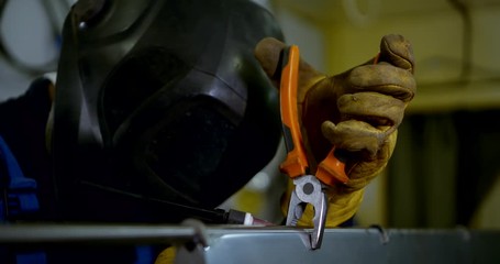 Closeup portrait of a welder in gloves and helmet detail works welding argon welding.