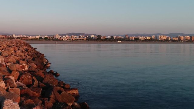 Vuelo de dron sobrevolando un espig&oacute;n solitario junto al mar mediterr&aacute;neo en calma de Valencia