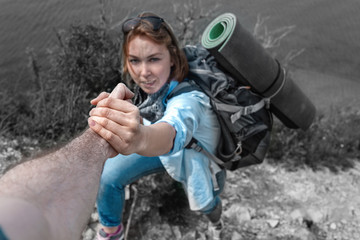 Woman tourist grabs the hand of his friend. In the background, the precipice and the sea. The...