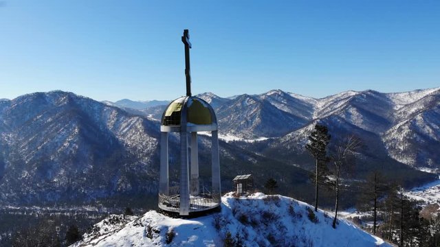 Chapel above mountain valley in winter aerial shot