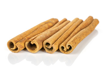 Group of four whole dry brown cinnamon isolated on white background