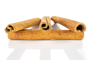 Group of four whole dry brown cinnamon isolated on white background