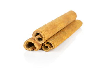 Group of three whole dry brown cinnamon isolated on white background