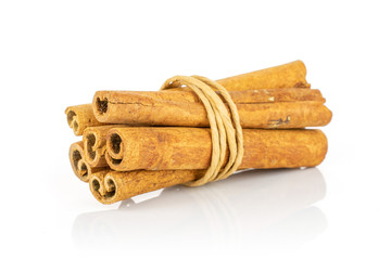 Group of six whole dry brown cinnamon wrapped in natural twine isolated on white background
