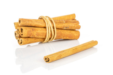 Group of seven whole dry brown cinnamon wrapped in natural twine isolated on white background