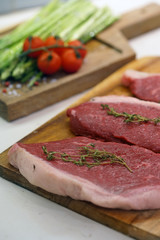 Raw Steak with green asparagus on wooden board