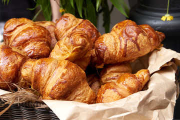 Croissants in a wicker basket on the counter, fresh croissants