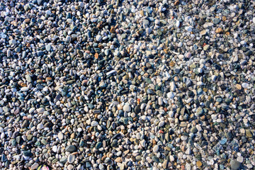 beach colored pebbles in the sea, top view, background