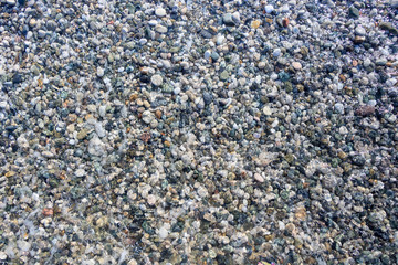 beach colored pebbles in the sea, top view, background