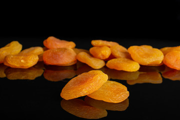 Lot of whole dried orange apricot isolated on black glass