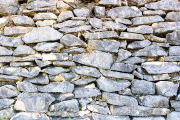 wall of old stones overgrown with grass, close-up background.