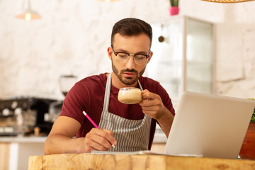 Busy businessman drinking cappuccino and working