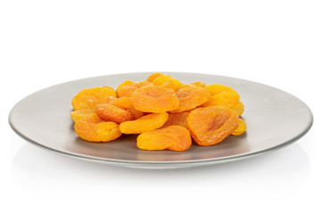 Lot of whole dried orange apricot on gray ceramic plate isolated on white background