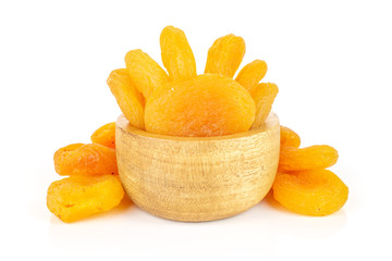 Lot of whole dried orange apricot in tiny wooden bowl isolated on white background