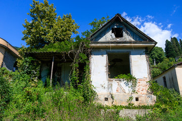 a crumbling old house with a grassy plot