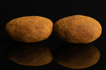Fototapeta na wymiar Group of two whole sweet brown chocolate cinnamon almond isolated on black glass