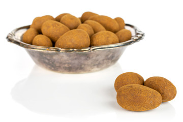Lot of whole sweet brown chocolate cinnamon almond in metal bowl isolated on white background